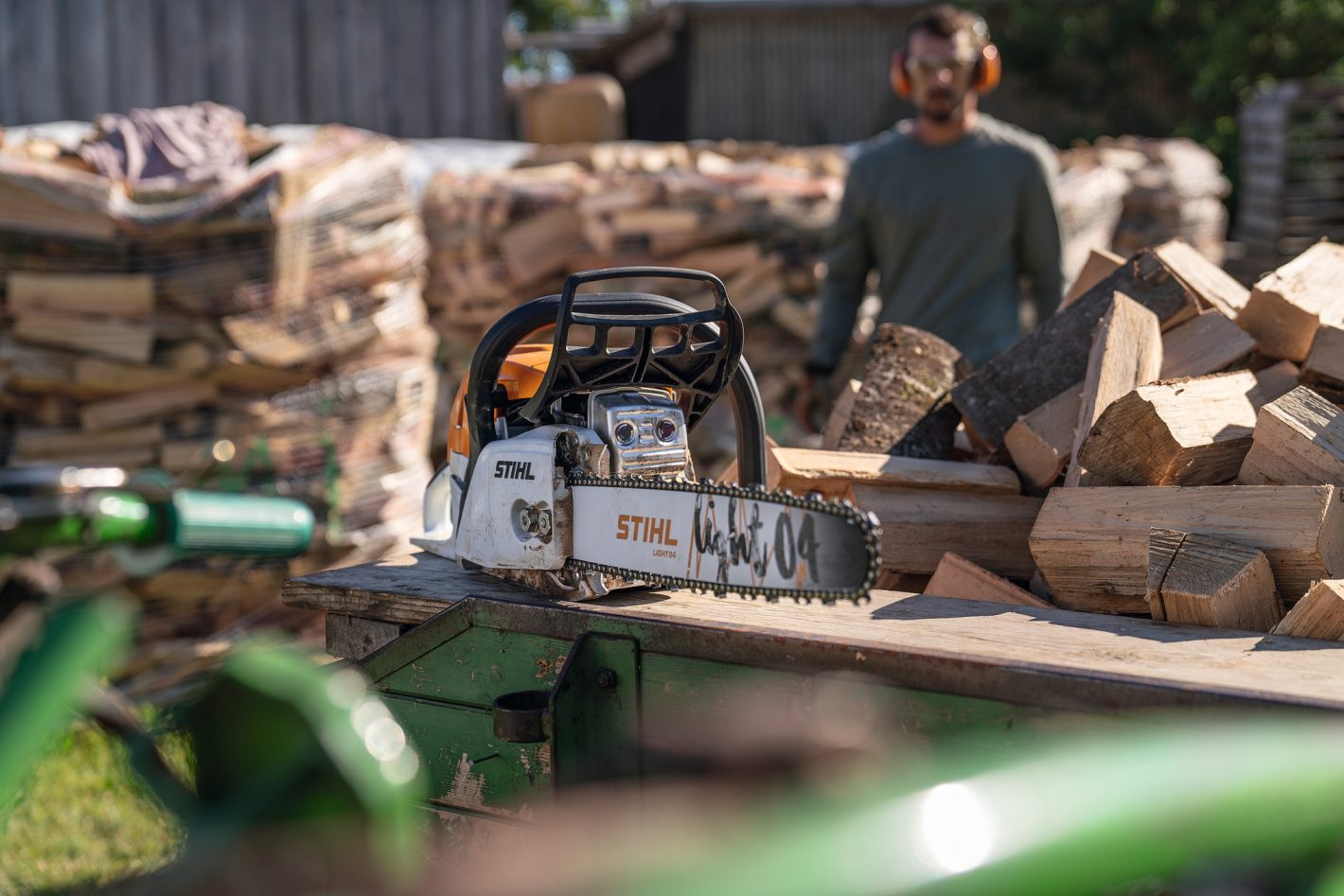 Stihl MS 271 Farm Boss chainsaw beside stacked firewood